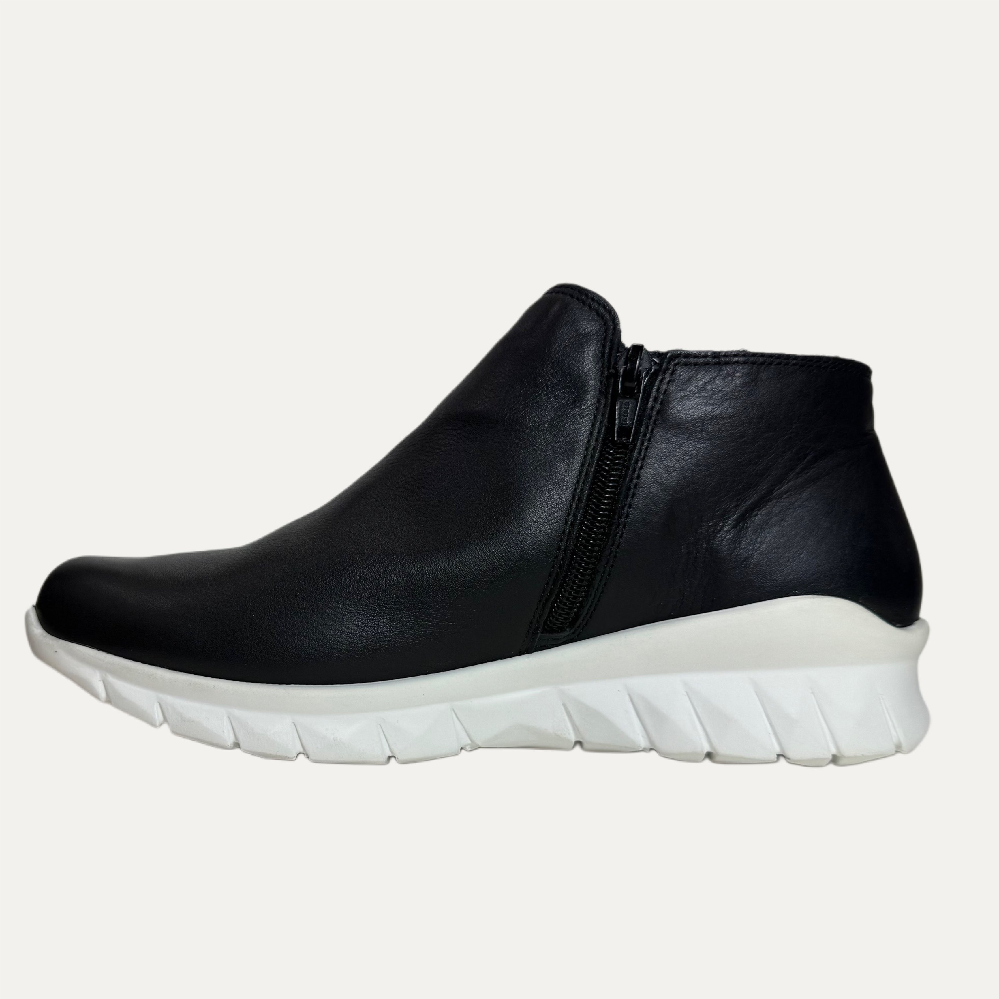 Black ankle boot with white sole on a white background