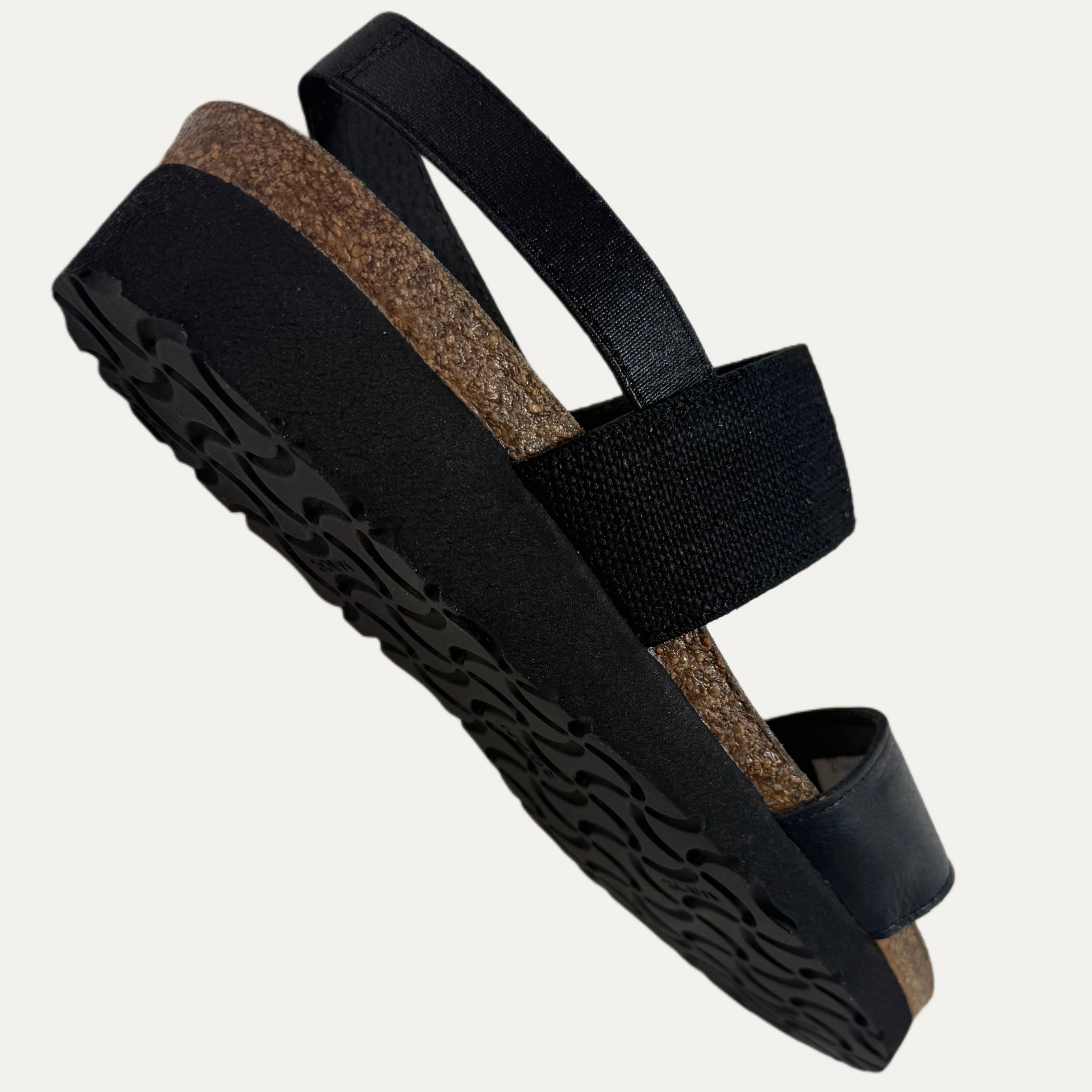 Black sandals with cork sole on a light gray background